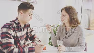 可爱的一对夫妇坐在咖啡馆的桌子旁。 他正在和他的女朋友交流，同时吃甜点。 <strong>真诚真诚</strong>